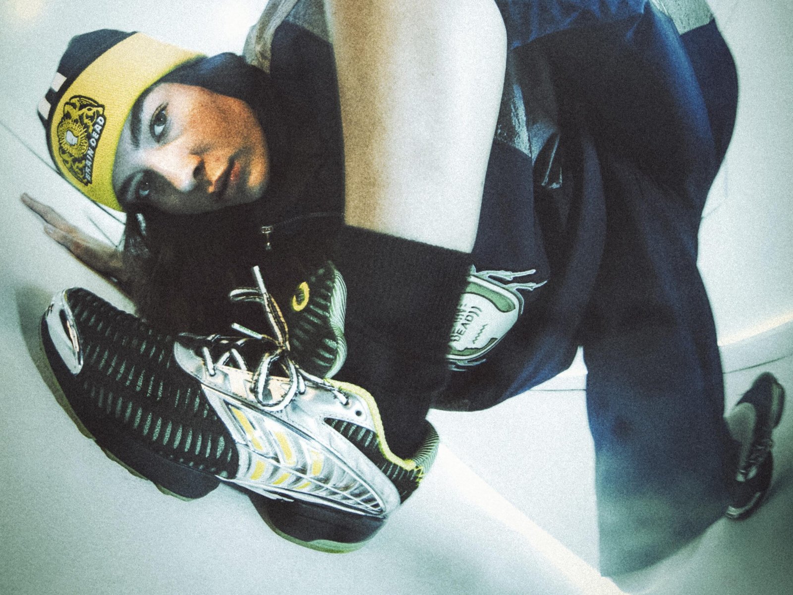  Having previously partnered on a number of collaborative collections, including takes on Tennis culture, Japanese Wrestling style, and a selection of iconic adidas silhouettes, this December, Brain Dead and the brand with the Three Stripes return to present a head-to-toe nostalgic capsule. Channeling the bold sporting and video game energy of the 2000s, the latest adidas Originals x Brain Dead collection delivers a full head-to-toe offering. The collection features reflective silver elements and shaped panels inspired by the adidas archive for apparel, along with two standout retro-futuristic silhouettes, also inspired from the adidas archive, complemented by matching accessories. The apparel offering boasts a number of key pieces, including a Japanese Noragi inspired Climacool track top and matching track pants, a metallic football-esque jersey and matching shorts, and an all over print goalkeeper jersey, as well as a track top, track pants, and a t-shirt. Each piece features Brain Dead graphics and custo crests. Rounding out the collection in the form of accessories are a sling bag and beanie. The footwear selection focuses on two silhouettes: the Climacool 2 and the Taekwondo Mei. Born in 2003 as the followup to the OG adidas Climacool sneaker, the Climacool 2 saw the silhouette updated with a futuristic vent system. Now, Braindead has brought its distinct aesthetic sensibility to the silhouette, featuring metallic vents, reflective green mesh, and yellow accents. The Taekwondo Mei Brain Dead, meanwhile, features a black upper with white stripes and an off-white outsole. Brain Dead and adidas Originals have produced a line of two collectibles inspired by classic video game culture, blending nostalgic aesthetics with the brand’s signature surreal style. These limited-edition figures capture the playful, experimental spirit of the early 2000s and will be raffled exclusively on CONFIRMED, running for the duration of the collection’s availability. While the collection can be purchased directly, the collectibles can only be won via raffle. Arriving in limited quantities on December 18th, the adidas Originals x Brain Dead collection is available via CONFIRMED, select adidas stores, select retailers, and on wearebraindead.com.