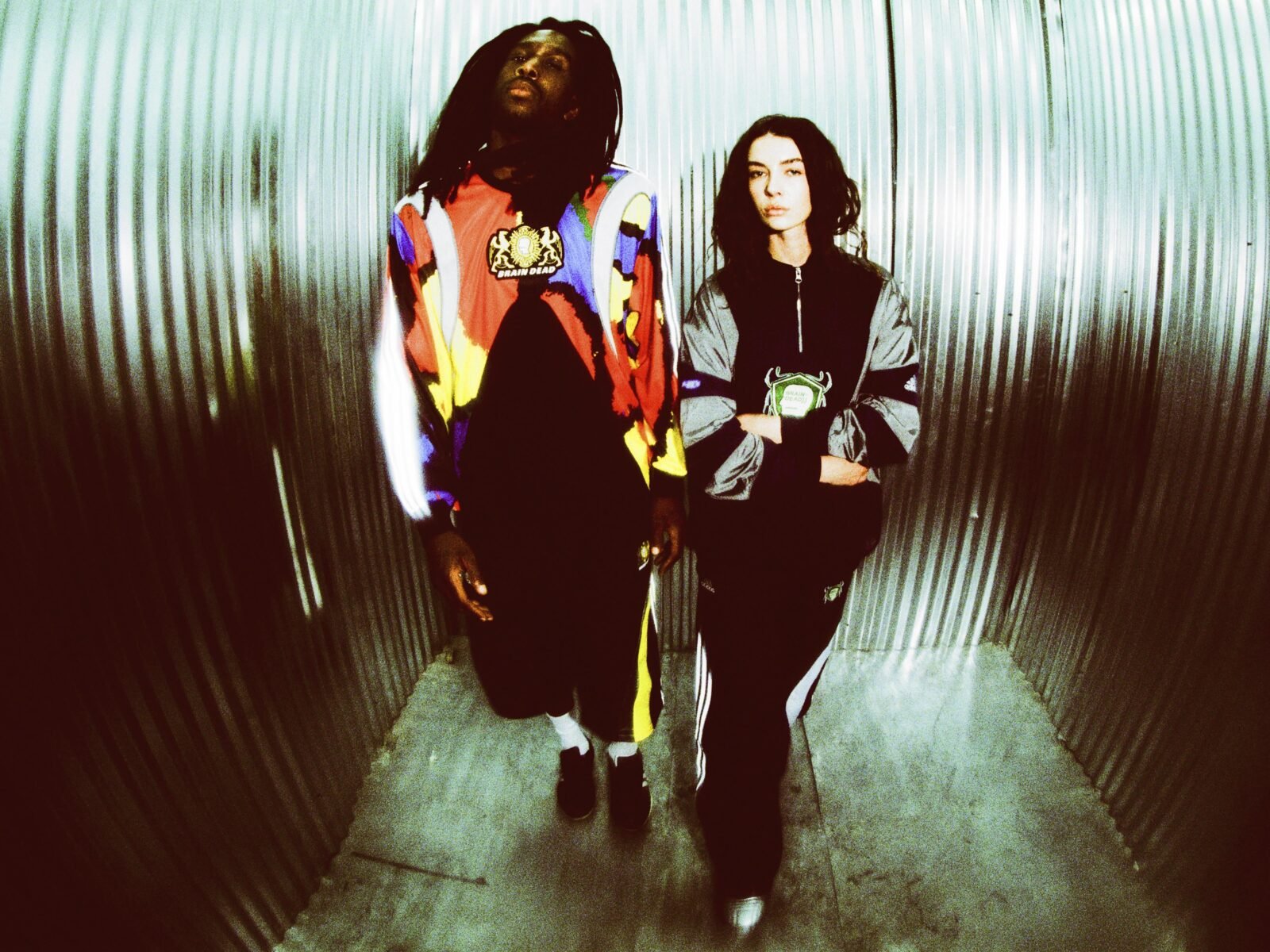 Having previously partnered on a number of collaborative collections, including takes on Tennis culture, Japanese Wrestling style, and a selection of iconic adidas silhouettes, this December, Brain Dead and the brand with the Three Stripes return to present a head-to-toe nostalgic capsule. Channeling the bold sporting and video game energy of the 2000s, the latest adidas Originals x Brain Dead collection delivers a full head-to-toe offering. The collection features reflective silver elements and shaped panels inspired by the adidas archive for apparel, along with two standout retro-futuristic silhouettes, also inspired from the adidas archive, complemented by matching accessories. The apparel offering boasts a number of key pieces, including a Japanese Noragi inspired Climacool track top and matching track pants, a metallic football-esque jersey and matching shorts, and an all over print goalkeeper jersey, as well as a track top, track pants, and a t-shirt. Each piece features Brain Dead graphics and custo crests. Rounding out the collection in the form of accessories are a sling bag and beanie. The footwear selection focuses on two silhouettes: the Climacool 2 and the Taekwondo Mei. Born in 2003 as the followup to the OG adidas Climacool sneaker, the Climacool 2 saw the silhouette updated with a futuristic vent system. Now, Braindead has brought its distinct aesthetic sensibility to the silhouette, featuring metallic vents, reflective green mesh, and yellow accents. The Taekwondo Mei Brain Dead, meanwhile, features a black upper with white stripes and an off-white outsole. Brain Dead and adidas Originals have produced a line of two collectibles inspired by classic video game culture, blending nostalgic aesthetics with the brand’s signature surreal style. These limited-edition figures capture the playful, experimental spirit of the early 2000s and will be raffled exclusively on CONFIRMED, running for the duration of the collection’s availability. While the collection can be purchased directly, the collectibles can only be won via raffle. Arriving in limited quantities on December 18th, the adidas Originals x Brain Dead collection is available via CONFIRMED, select adidas stores, select retailers, and on wearebraindead.com.